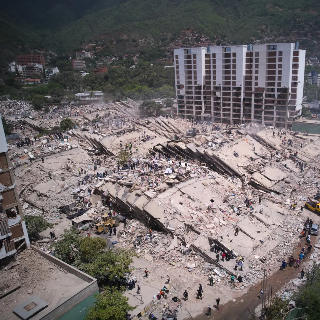 Residentes y rescatistas buscan entre los escombros dos días después de un sismo que remeció La Guaira, Venezuela, el 26 de junio de 2026. (AP Foto/Juan Pablo Arraez)
